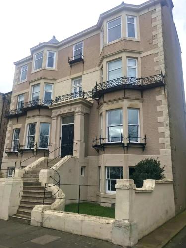 a large building with stairs in front of it at Collingwood House Tynemouth in Tynemouth
