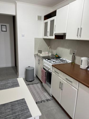 a kitchen with white cabinets and a stove at Apartament Korczaka in Suwałki