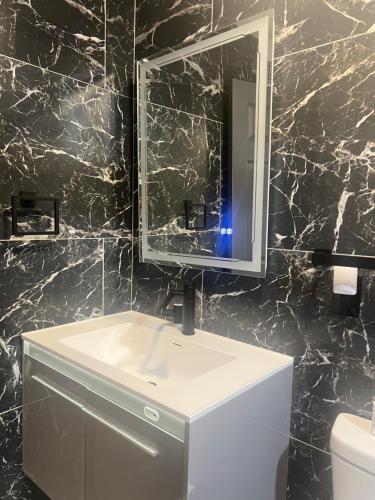 a bathroom with a white sink and a mirror at The Secret Garden Games Getaway in Orlando