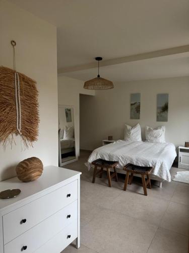 a bedroom with a white bed and a white dresser at Hortense in Étaples