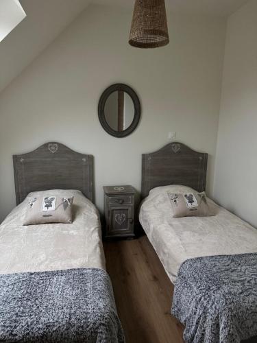 a bedroom with two beds and a mirror on the wall at Hortense in Étaples