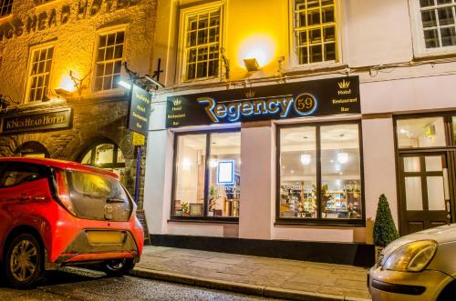 a small car parked in front of a store at The Kings Head Hotel in Abergavenny