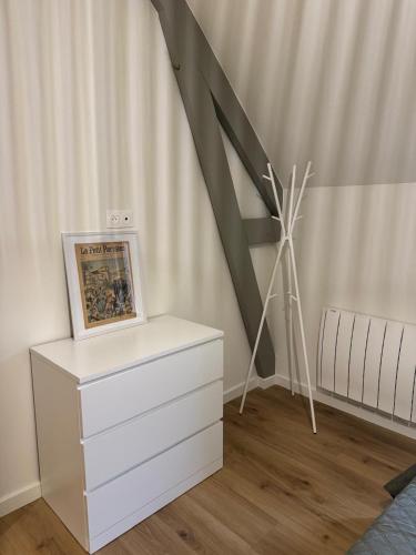 a room with a painting on a dresser and a roof at Hortense in Étaples