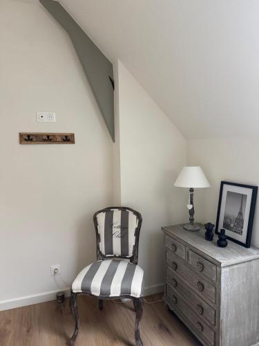 a chair sitting next to a dresser in a room at Hortense in Étaples
