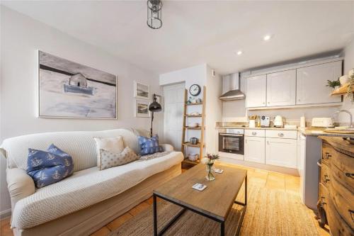 ein Wohnzimmer mit Sofa und Tisch in der Unterkunft Ringmore Cottage - Salcombe - View over estuary in Salcombe