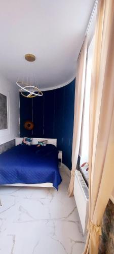 a blue bedroom with a blue bed and curtains at Apartament Azzurro - Old Town in Kłodzko