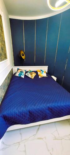 a bed with blue sheets and pillows in a room at Apartament Azzurro - Old Town in Kłodzko