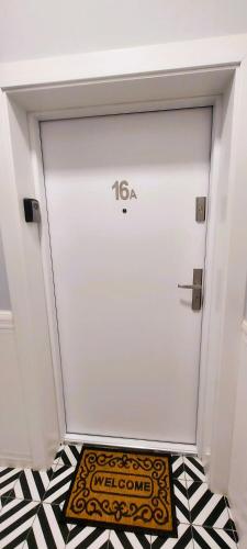 a white garage door with a welcome mat on the floor at Apartament Azzurro - Old Town in Kłodzko