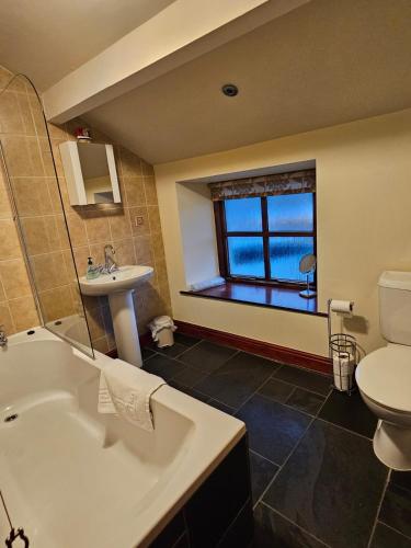 a bathroom with a tub and a sink and a toilet at Causeway Cottage in Cartmel