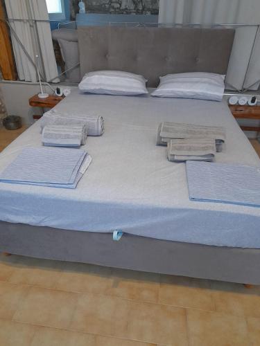 a large bed with towels on top of it at sofitsasplace in Kokkari