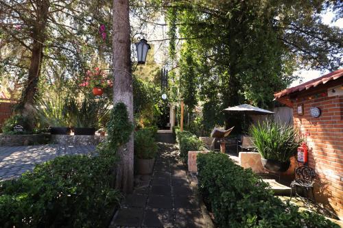a garden with a tree and a brick building at Casa de campo Huasca in Huasca de Ocampo