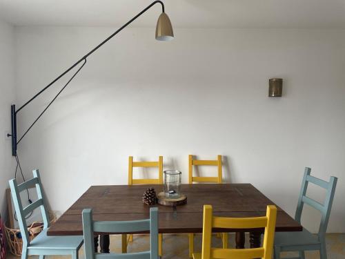 une salle à manger avec une table et des chaises en bois dans l'établissement Maison calme à un 15min à pied de la plage, à Royan