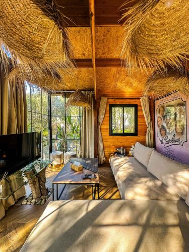 a living room with a couch and a tv at Evergreen 1BR Wood Cabin with Bassin & Terrace in Al Azifat