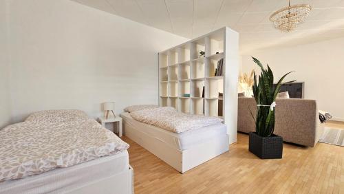 Un dormitorio blanco con una cama y una planta en Ferienhaus Arno - Thüringer Wald, en Waltershausen