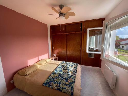 une chambre avec un lit et un ventilateur de plafond dans l'établissement Maison calme à un 15min à pied de la plage, à Royan