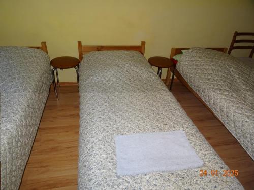 three beds in a room with a white towel on them at Wynajem pokoi Białystok in Białystok