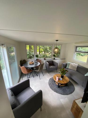 a living room with a couch and a table at Modern chalet in de bossen van de Veluwe in Epe