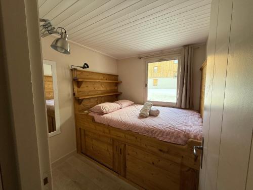 une chambre avec un lit dans une pièce avec une fenêtre dans l'établissement CRISTALLINES App 6 personnes Val d'Isère Centre, Garage, à Le Joseray