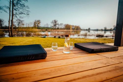 a wooden table with a glass of wine and a wallet at Lawendowy domek in Iława