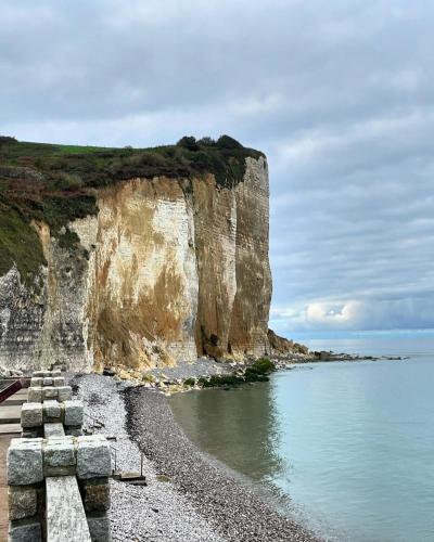 a large cliff next to a body of water at Longère cœur de village proche des plages in Sassetot-le-Mauconduit
