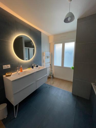 une salle de bain avec un lavabo et un miroir dans l'établissement Maison Familiale idéale pour les Vacances/Weekends, à Dinard