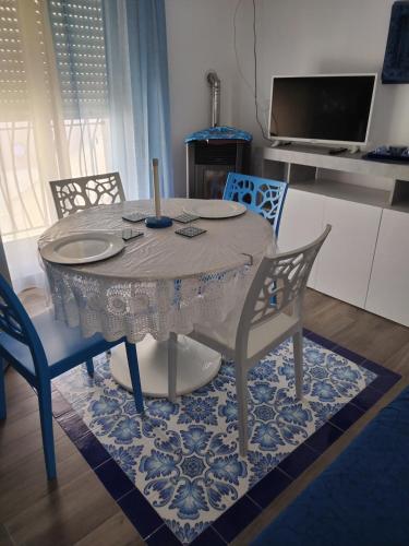 a dining room table with two chairs and a table with a candle at Casa Azzurra in Ginosa Marina