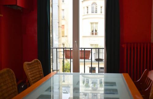 une table en verre dans une chambre avec vue sur un bâtiment dans l'établissement Lovely flat in Latin quarter, à Paris