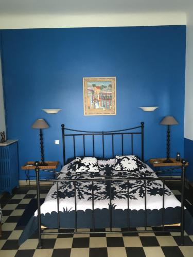 - une chambre bleue avec un lit et un mur bleu dans l'établissement Villa Les Algues, les pieds dans l'eau sur la plage de Rènecros, à Bandol