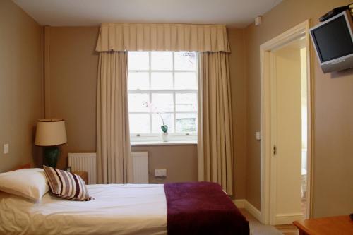 a bedroom with a bed and a window at The Kings Head Hotel in Abergavenny
