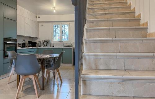 une cuisine et une salle à manger avec une table et des escaliers dans l'établissement 3 Bedroom Cozy Home In Beauvoisin, à Beauvoisin