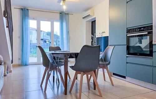 - une cuisine avec une table à manger et des chaises dans l'établissement 3 Bedroom Cozy Home In Beauvoisin, à Beauvoisin