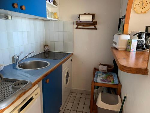 une petite cuisine avec un évier et une machine à laver dans l'établissement LES INDES GALANTES, au Cap d'Agde