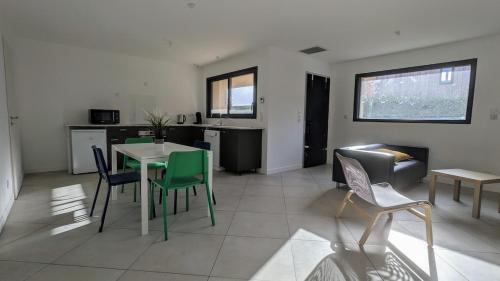 une cuisine et un salon avec une table et des chaises dans l'établissement #03 - Le 60 - Gîtes confortables combinés, à Villieu