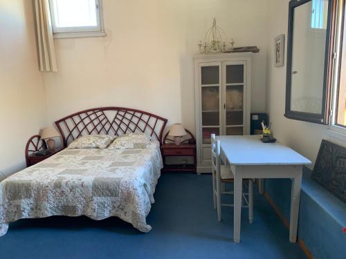 une chambre avec un lit, une table et un bureau dans l'établissement LES INDES GALANTES, au Cap d'Agde