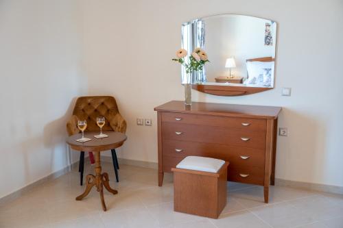 a bedroom with a dresser and a table with a mirror at Irene Luxury Villa in Metaxáta