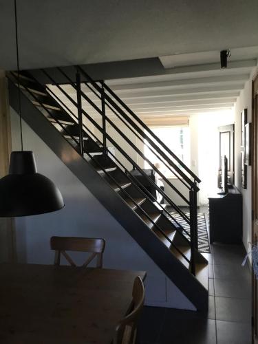 a staircase in a room with a table and a lamp at Côté campagne in Pierrefaites