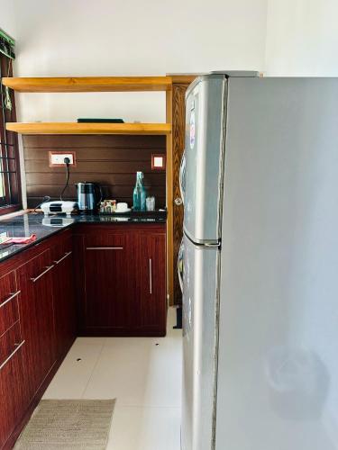 a kitchen with a stainless steel refrigerator in it at Aroma Villa Homestay in Polonnaruwa