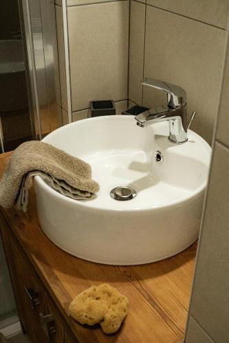 La salle de bains est pourvue d'un lavabo et d'une serviette sur un comptoir en bois. dans l'établissement Appartement prestige à Chantemerle, à Saint-Chaffrey