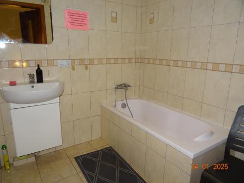 a bathroom with a bath tub and a sink at Wynajem pokoi Białystok in Białystok