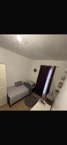 une petite pièce avec un lit et une fenêtre dans l'établissement Studette, à Paris