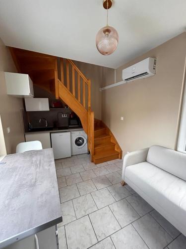 un salon avec un canapé et un escalier dans l'établissement Appartement F1 duplex Hyper centre, à Saint-Dizier