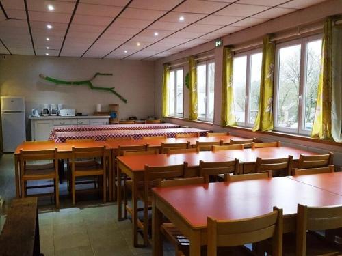 a dining room with tables and chairs and windows at Gite D'étape port de Carhaix in Carhaix-Plouguer