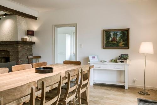 a kitchen and dining room with a wooden table and chairs at Villa Aluma in Sint-Truiden