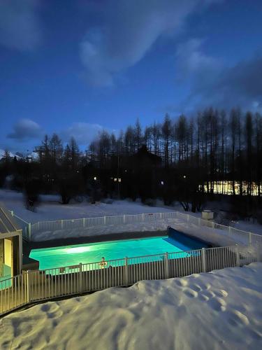 - une piscine couverte de neige la nuit dans l'établissement Appartement ALPE D HUEZ dans Résidence Pierre et Vacances Les Bergers, à Huez