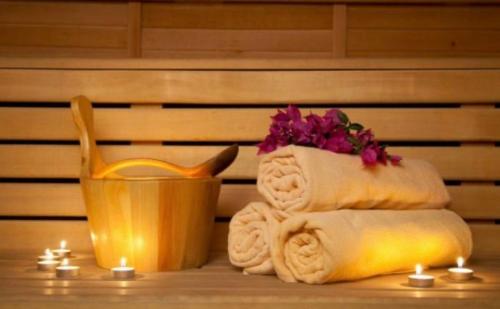 a pile of towels and a flower in a yellow pot at Hotel MERIDA in Blagoevgrad