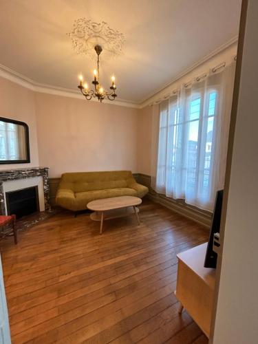 un salon avec un canapé vert et un lustre dans l'établissement la villa des hortensias, à Romorantin-Lanthenay