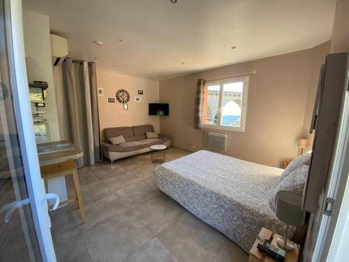 a bedroom with a bed and a couch at STUDIO pied village EZE - dans VILLA - Parking Gratuit in Èze