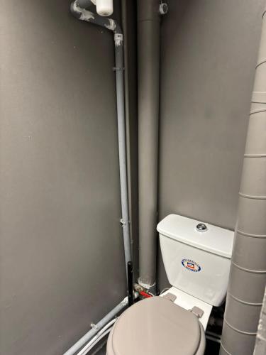 - une salle de bains avec des toilettes blanches dans une cabine dans l'établissement Love&love room, à Les Clayes-sous-Bois