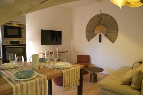 a living room with a table and a fan on the wall at Dijon Hypercentre - Loge Pompon in Dijon