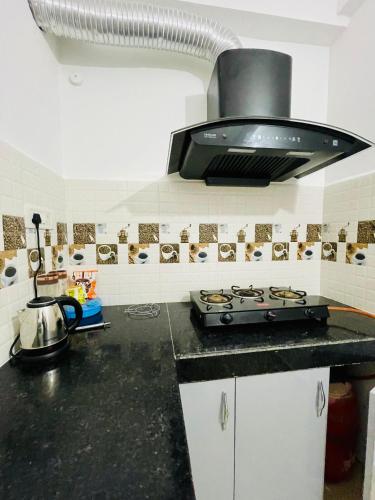 a kitchen with a black counter top with a stove at Classic Homes Airport in Guwahati